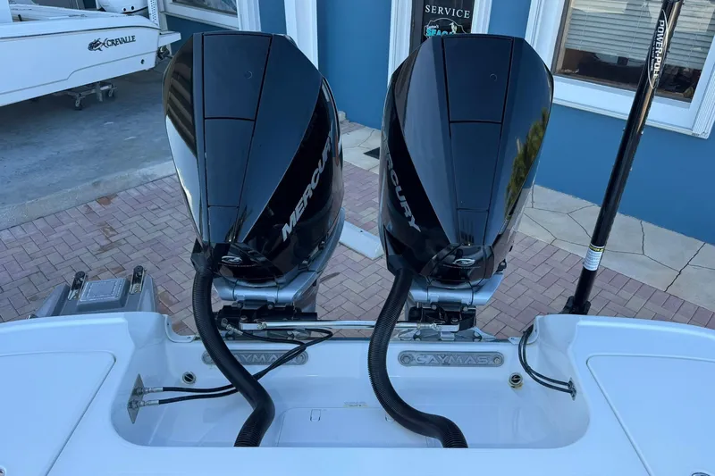 Slide: The Image of 2022 Caymas 28 HB Twin with dual Mercury outboard engines, docked near a blue building. - 8
