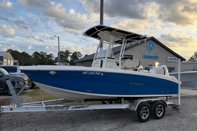 The Image of 2022 Stingray 216 CC boat on trailer at Revis Yacht Sales dealership. - 1