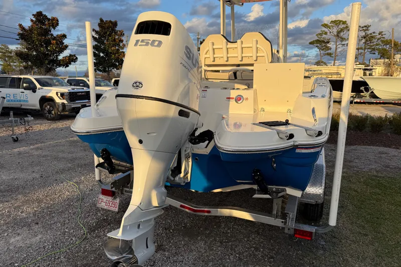 Slide: The Image of 2022 Stingray 216 CC boat with 150 HP engine on trailer, parked outdoors. - 11