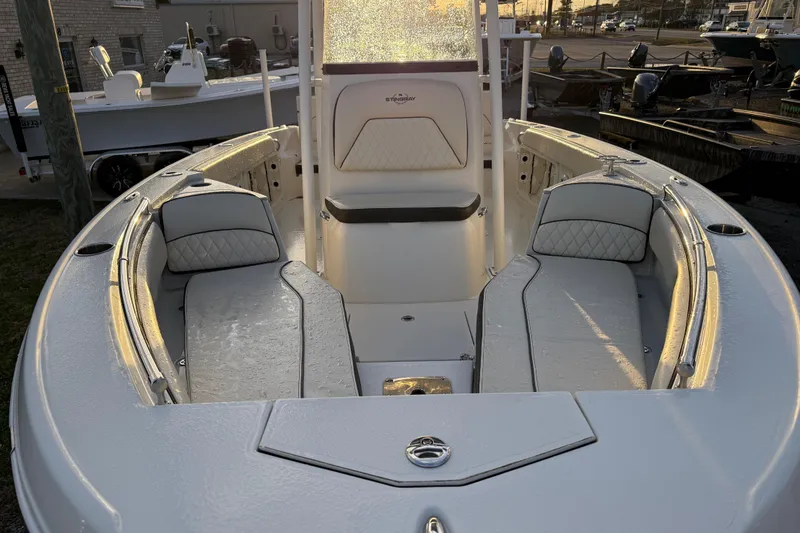 Slide: The Image of 2022 Stingray 216 CC boat interior with cushioned seating and sleek design. - 15