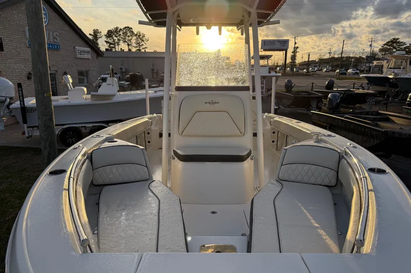 Slide: The Image of 2022 Stingray 216 CC boat interior at sunset, showcasing seating and helm. - 16
