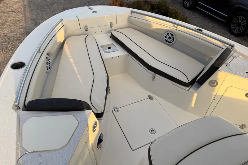 Slide: The Image of 2022 Stingray 216 CC boat interior with cushioned seating and storage compartments. - 17