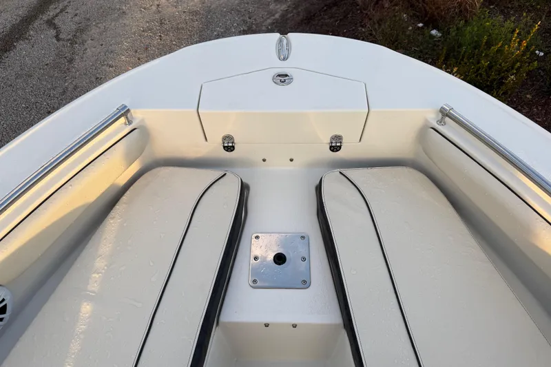 Slide: The Image of 2022 Stingray 216 CC boat interior with cushioned seating and storage compartment. - 19