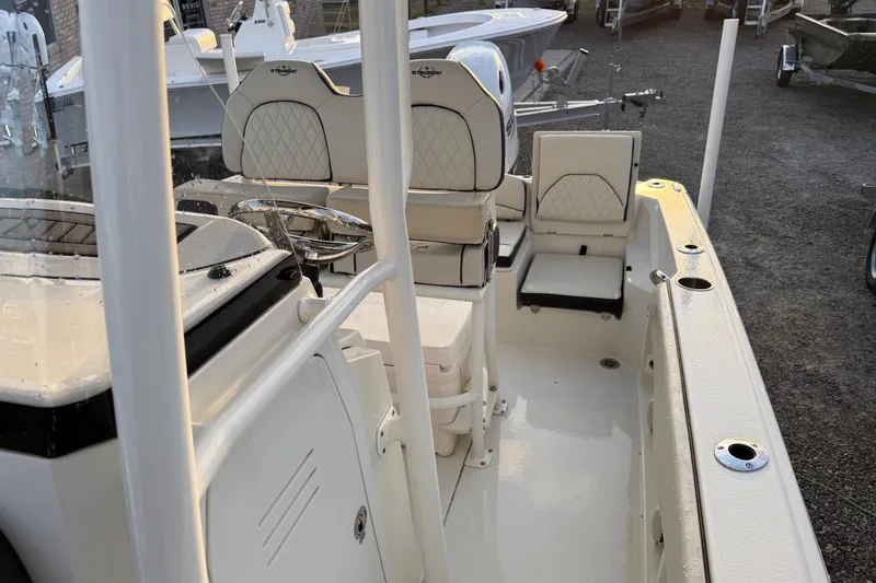Slide: The Image of 2022 Stingray 216 CC boat interior with cushioned seating and steering console. - 22