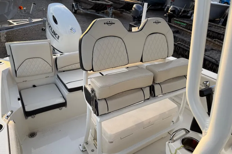 Slide: The Image of 2022 Stingray 216 CC boat interior with cushioned seating and Suzuki outboard motor. - 26