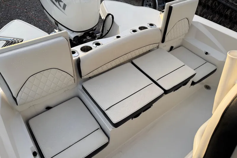 Slide: The Image of 2022 Stingray 216 CC boat interior with cushioned seating and cup holders. - 27