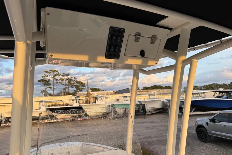 Slide: The Image of 2022 Stingray 216 CC boat console with overhead storage, parked in a marina. - 31