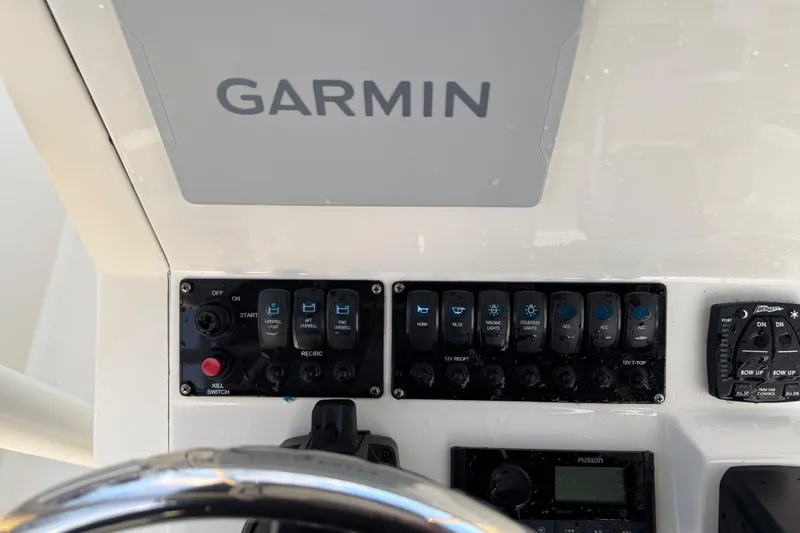 Slide: The Image of Control panel of 2022 Stingray 216 CC boat with Garmin display and switches. - 33