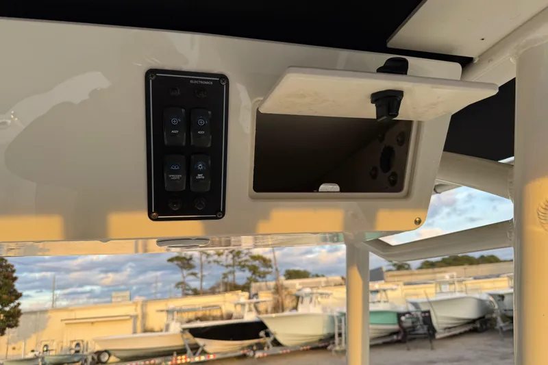Slide: The Image of 2022 Stingray 216 CC boat console with electronic controls and storage compartment. - 34