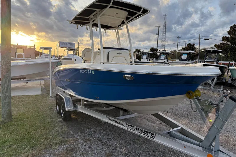 Slide: The Image of 2022 Stingray 216 CC boat on trailer at sunset, showcasing sleek blue design. - 6
