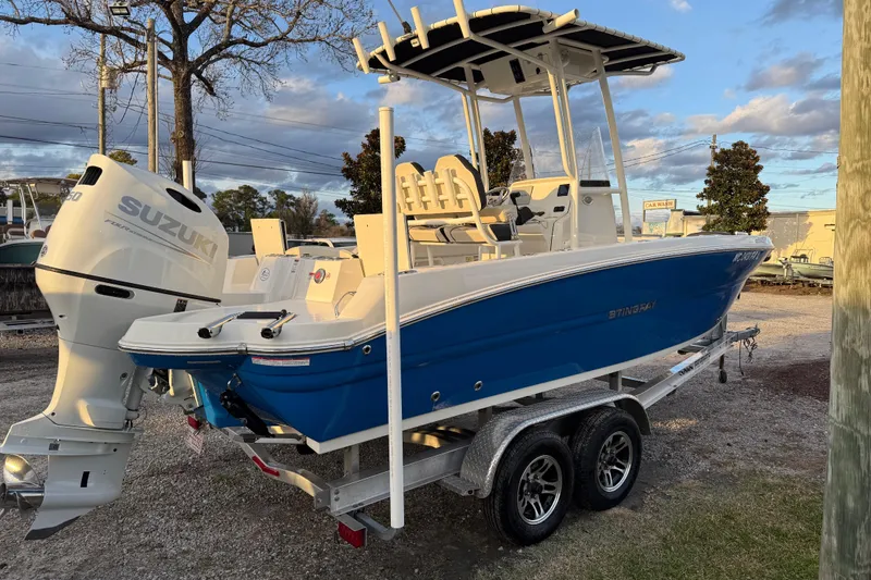 Slide: The Image of 2022 Stingray 216 CC boat with Suzuki engine on a trailer, parked outdoors. - 9