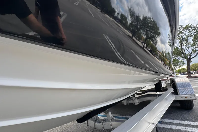 Slide: The Image of 2010 Paramount Sportfisherman 21' boat on trailer, glossy black and white hull. - 11