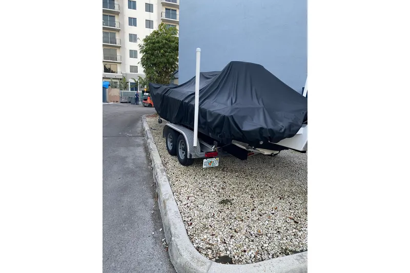 Slide: The Image of 2010 Paramount Sportfisherman 21' boat covered on a trailer in urban setting. - 58