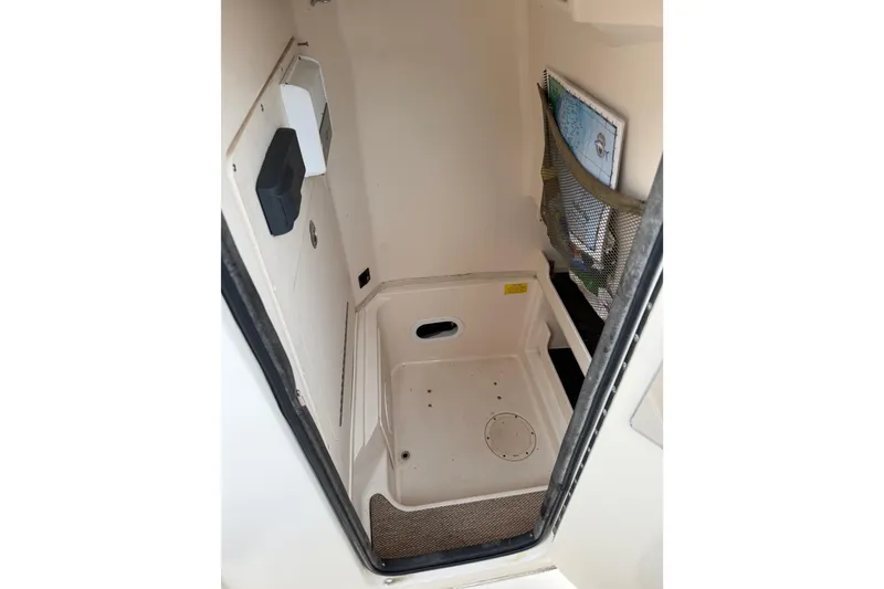 Slide: The Image of Interior of 2015 Grady-White Fisherman 257 boat, featuring storage compartment and map holder. - 16