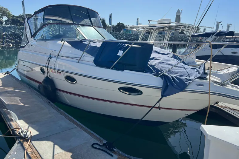 Slide: The Image of 2004 Maxum 2900 SE boat docked at marina, covered with blue tarp. - 22