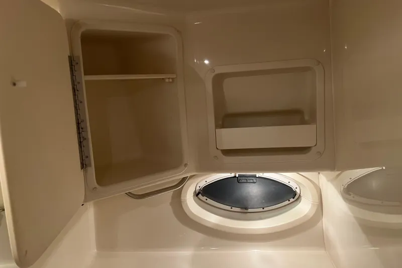 Slide: The Image of 2004 Maxum 2900 SE cabin interior with gray cushioned seating and small window. - 7