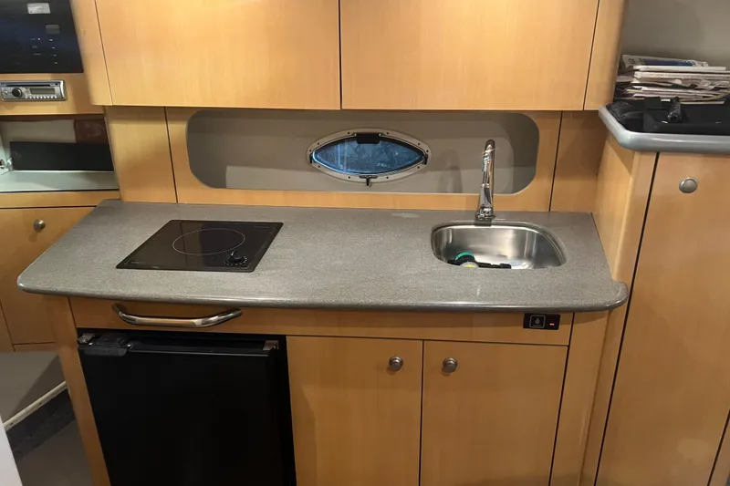 Slide: The Image of 2004 Maxum 2900 SE cabin interior with kitchenette and seating area. - 8