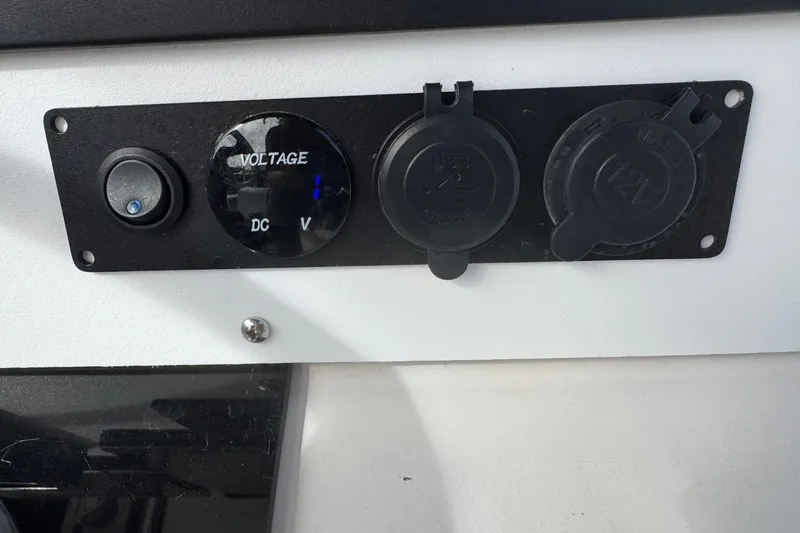 Slide: The Image of Control panel with voltage gauge and USB ports on a 2006 May-Craft 2000CC boat. - 11