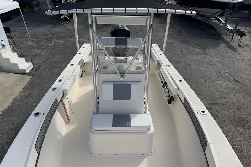 Slide: The Image of 2006 May-Craft 2000CC boat interior with seating and console, docked on pavement. - 16