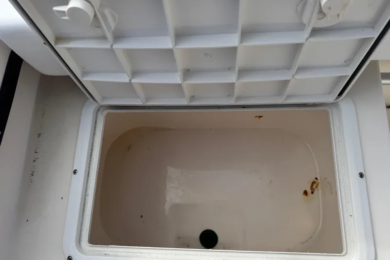 Slide: The Image of Open storage compartment on a 2006 May-Craft 2000CC boat, showing interior details. - 25