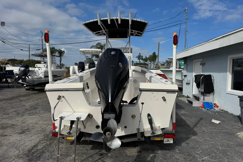 Slide: The Image of 2006 May-Craft 2000CC boat with outboard motor, parked outdoors under blue sky. - 3