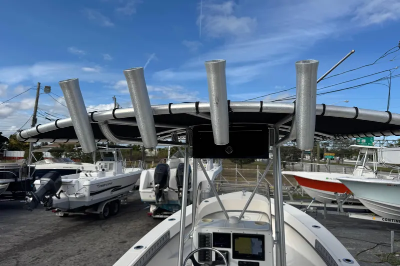 Slide: The Image of 2006 May-Craft 2000CC boat with rod holders and console, under a clear blue sky. - 31