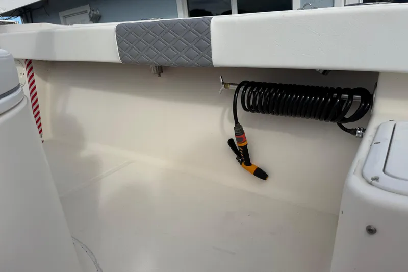 Slide: The Image of 2006 May-Craft 2000CC boat interior with coiled hose and cushioned panel. - 33