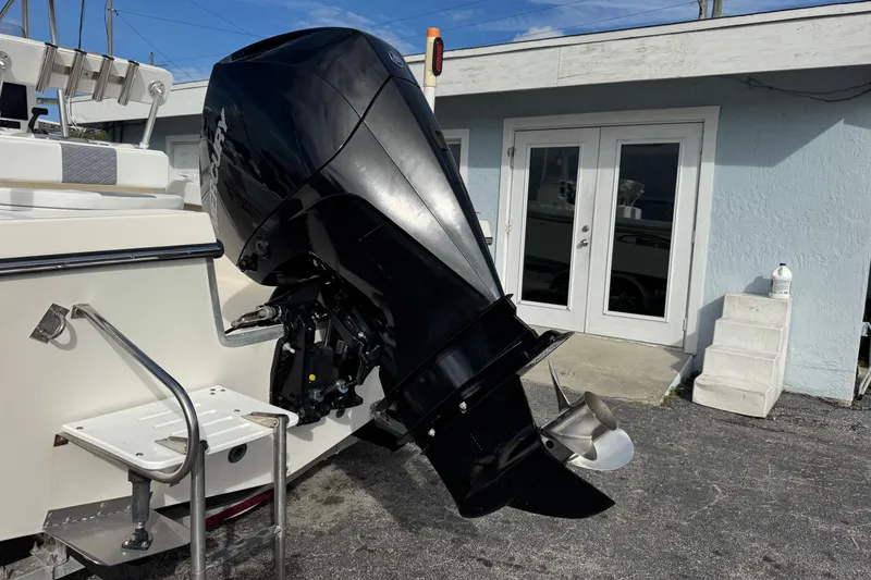 Slide: The Image of 2006 May-Craft 2000CC boat with a powerful outboard motor, parked near a building. - 34