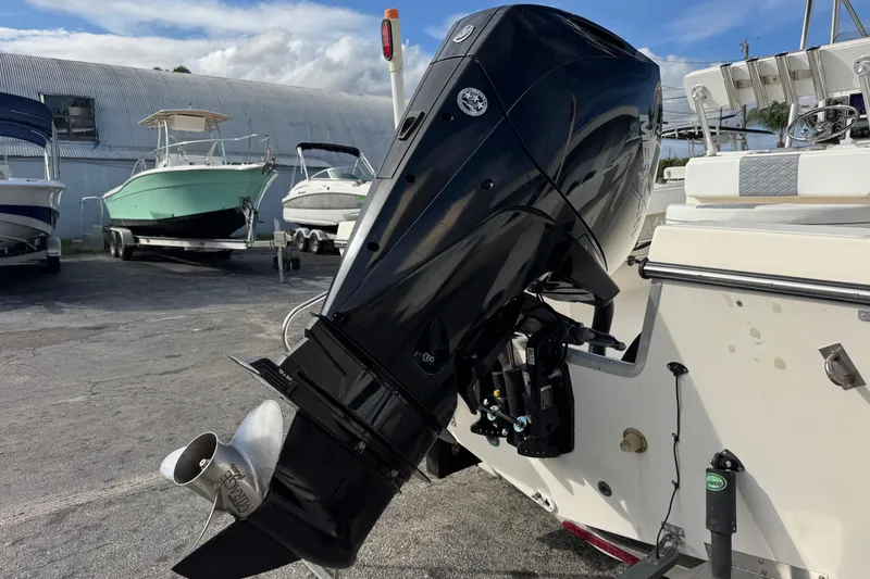 Slide: The Image of 2006 May-Craft 2000CC boat with a powerful outboard motor in a marina setting. - 36