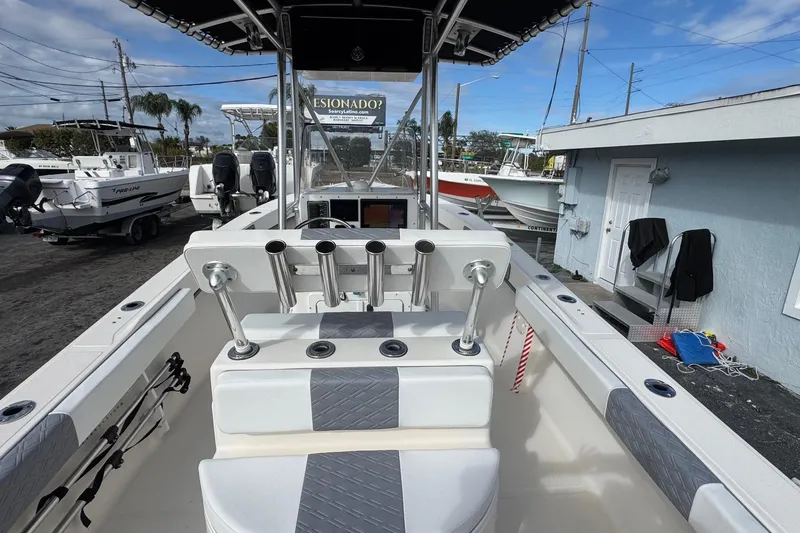 Slide: The Image of 2006 May-Craft 2000CC boat interior with rod holders and console, docked outdoors. - 4