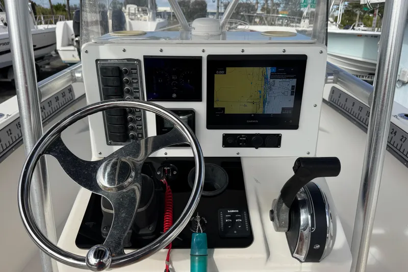 Slide: The Image of 2006 May-Craft 2000CC boat console with steering wheel, GPS, and throttle controls. - 5