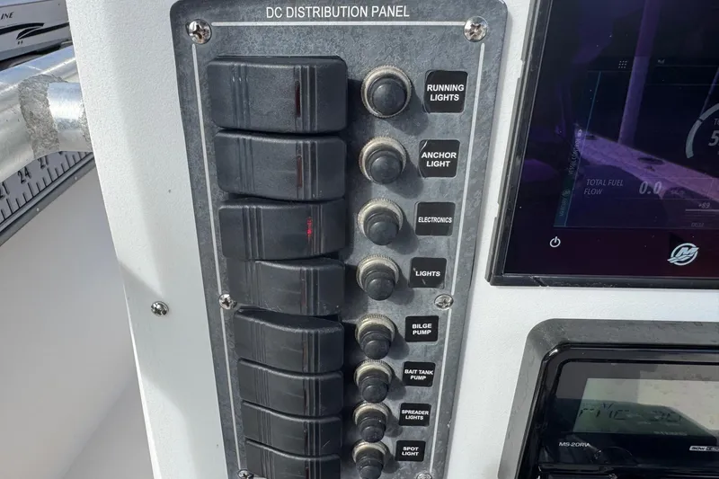 Slide: The Image of DC distribution panel on a 2006 May-Craft 2000CC boat, featuring various switches. - 9