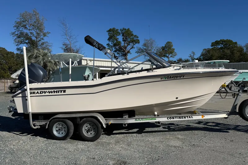 The Image of 2015 Grady-White Freedom 192 boat on trailer, parked outdoors under clear blue sky. - 0