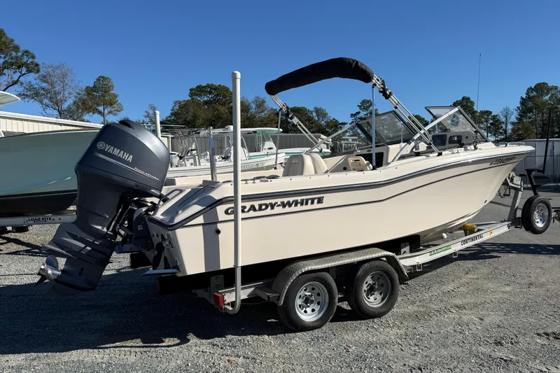 Slide: The Image of 2015 Grady-White Freedom 192 boat on trailer, parked outdoors under clear blue sky. - 2