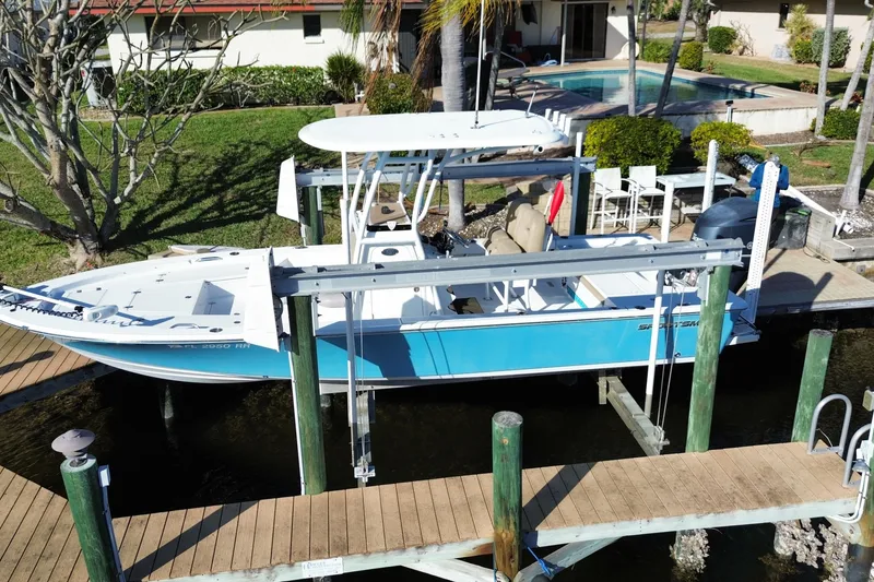 Slide: The Image of 2018 Sportsman Masters 247 Bay Boat docked near a waterfront home with a pool. - 15