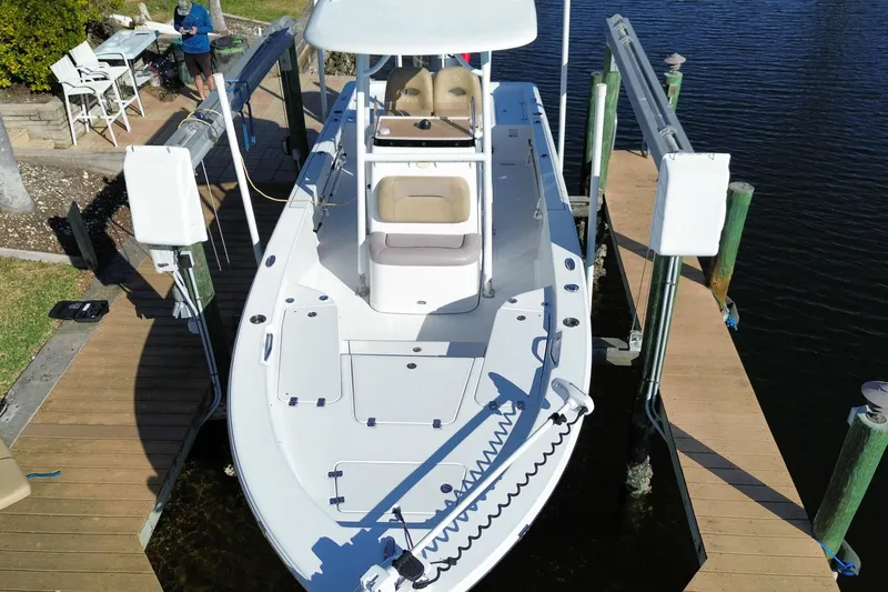 Slide: The Image of 2018 Sportsman Masters 247 Bay Boat docked on a lift by the water. - 17