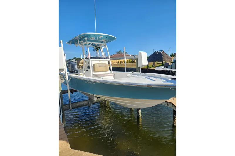 Slide: The Image of 2018 Sportsman Masters 247 Bay Boat docked on a lift, clear blue sky. - 2