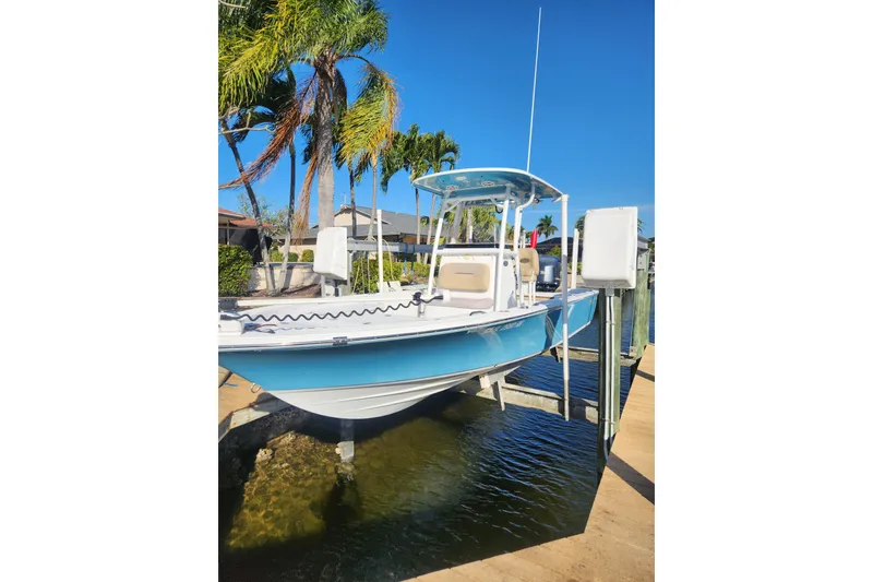Slide: The Image of 2018 Sportsman Masters 247 Bay Boat docked near palm trees under clear blue sky. - 3