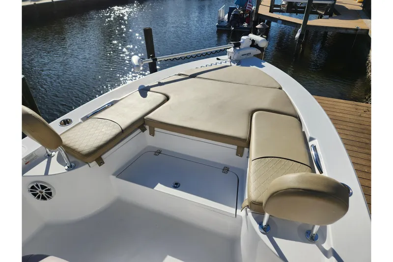 Slide: The Image of 2018 Sportsman Masters 247 Bay Boat with cushioned seating, docked by the water. - 5