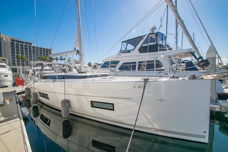 The Image of 2021 Bavaria C45 yacht docked at marina, reflecting on calm water. - 0
