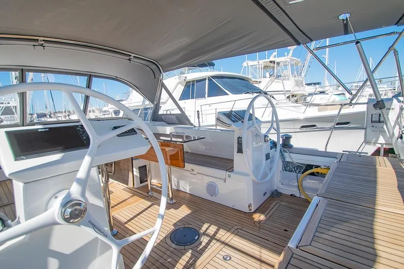 Slide: The Image of 2021 Bavaria C45 yacht cockpit with dual steering wheels and teak flooring in marina setting. - 20