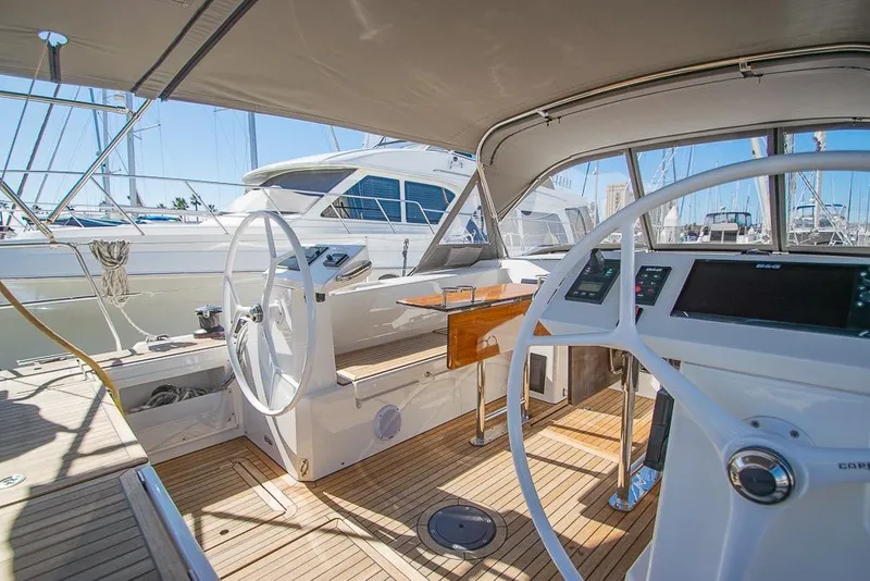 Slide: The Image of Interior view of a 2021 Bavaria C45 yacht, featuring dual steering wheels and modern navigation equipment. - 21