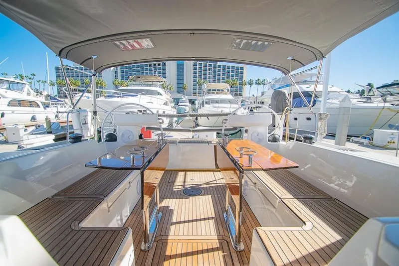 Slide: The Image of Spacious deck of 2021 Bavaria C45 yacht in marina, featuring elegant wood finish and seating. - 23