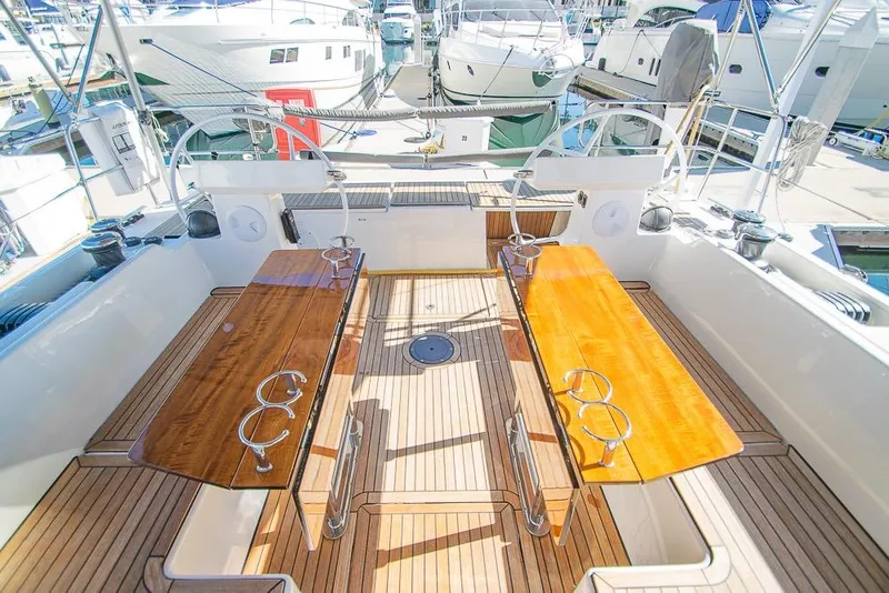 Slide: The Image of Spacious deck of 2021 Bavaria C45 yacht with wooden seating and steering wheels. - 24