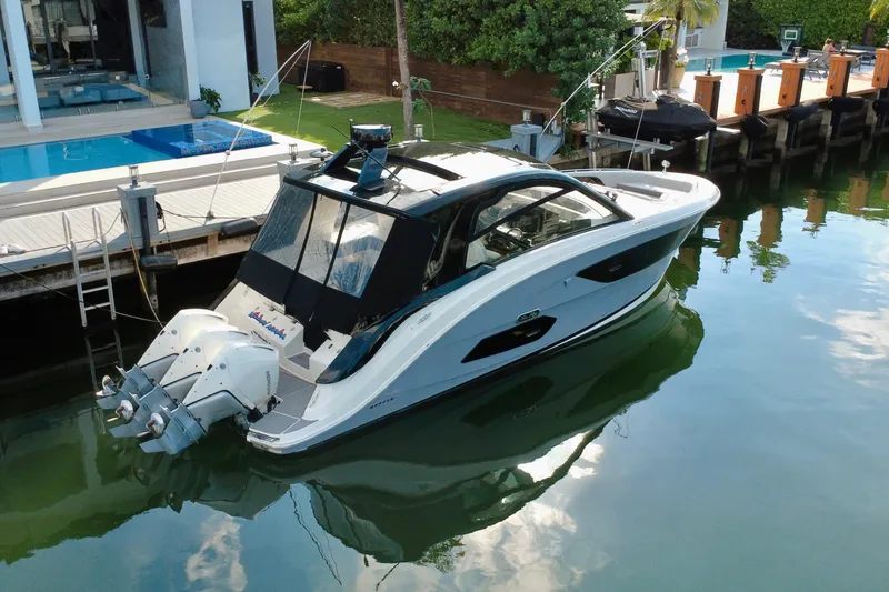 Slide: The Image of 2022 Sea Ray Sundancer 370 Outboard docked by a luxurious waterfront home. - 1