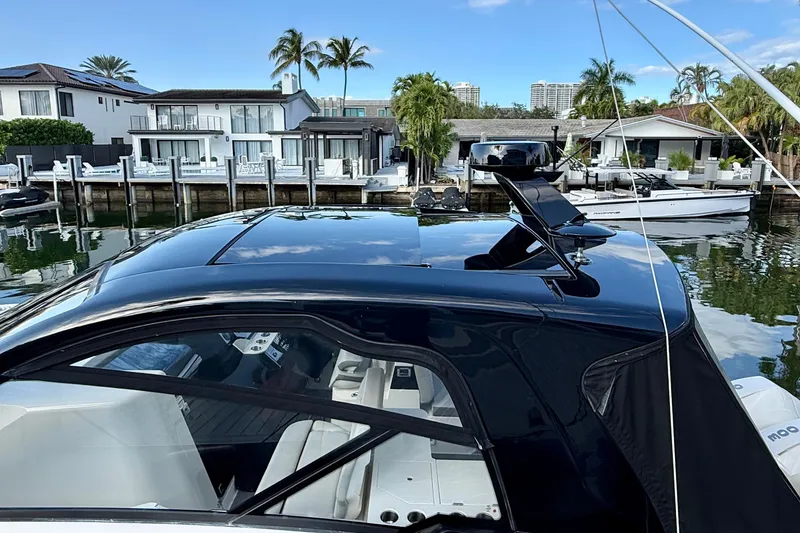 Slide: The Image of 2022 Sea Ray Sundancer 370 Outboard docked near waterfront homes, showcasing sleek design. - 11