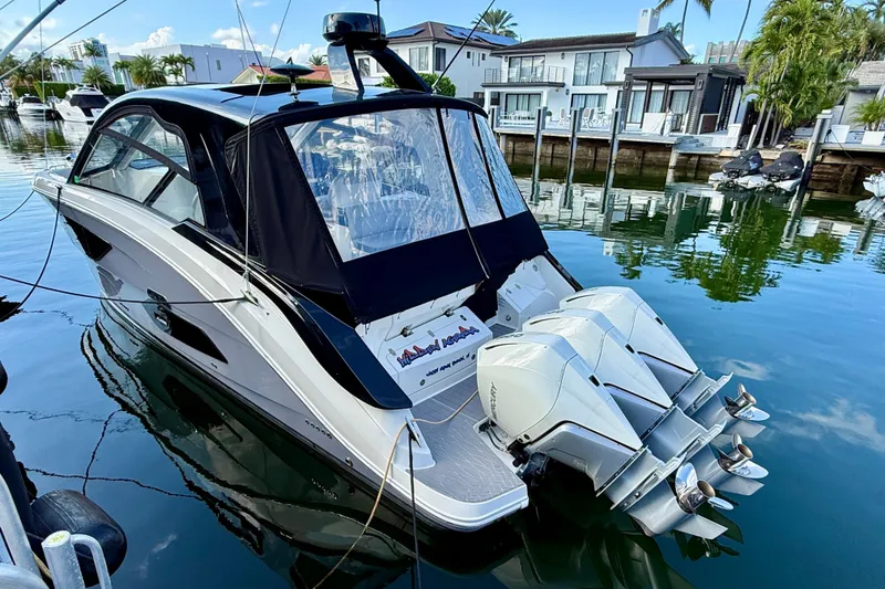 Slide: The Image of 2022 Sea Ray Sundancer 370 Outboard docked in a serene waterfront setting. - 12