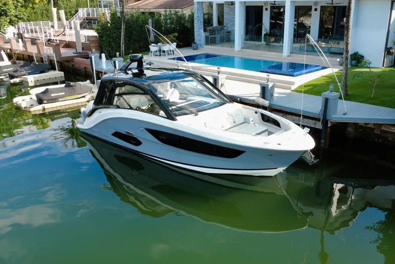 Slide: The Image of 2022 Sea Ray Sundancer 370 Outboard docked by a luxurious waterfront home. - 2
