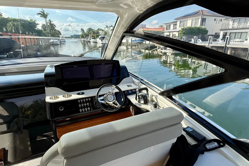 Slide: The Image of 2022 Sea Ray Sundancer 370 Outboard helm with dual screens, dockside view. - 22