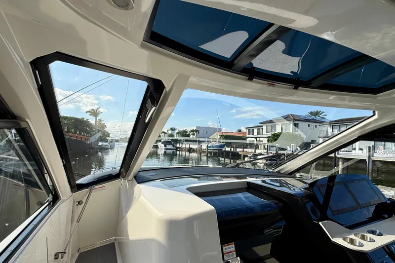 Slide: The Image of 2022 Sea Ray Sundancer 370 Outboard interior view with waterfront houses in background. - 26